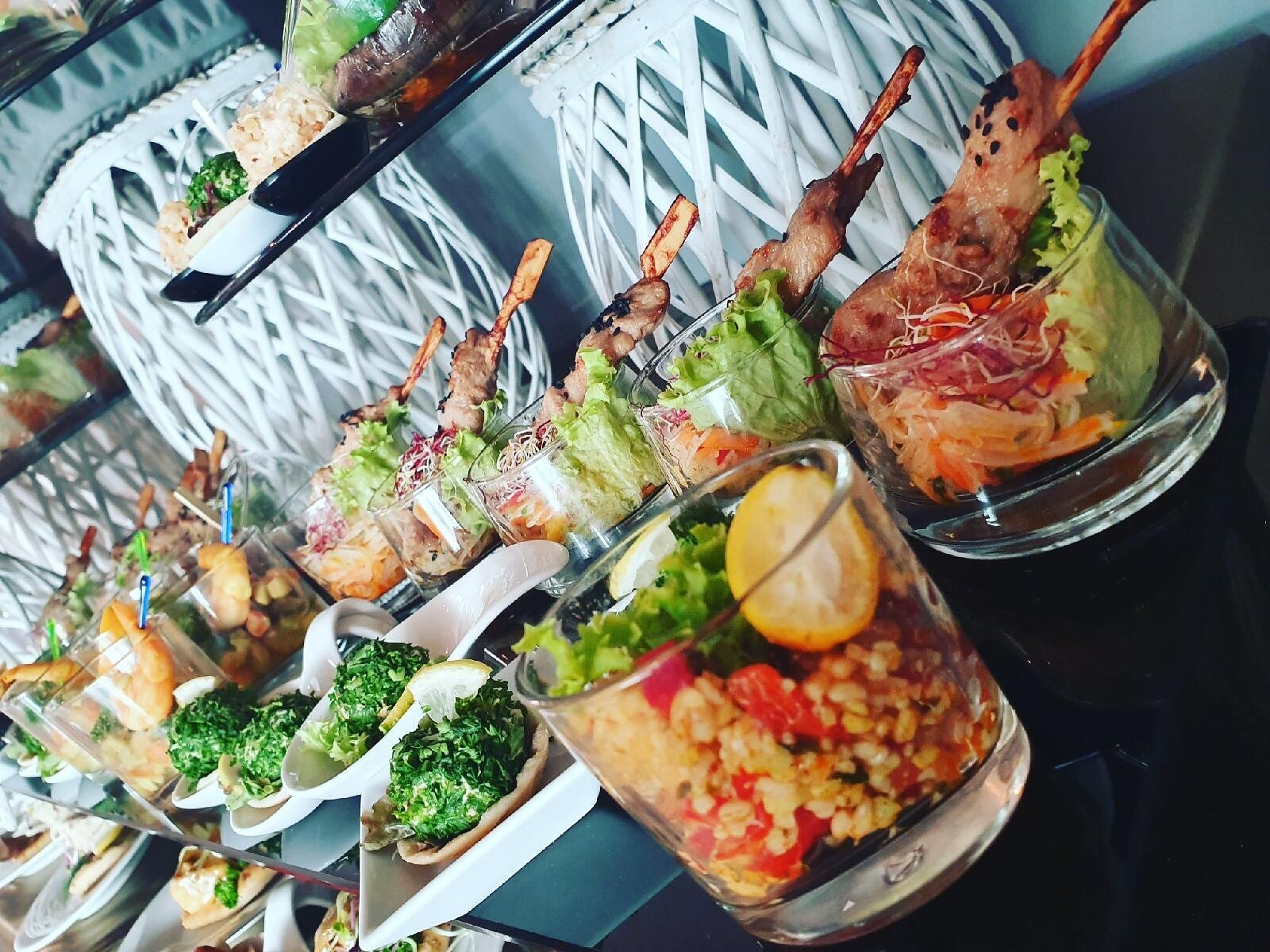 Fingerfood im Glas mit Fleischspießen, Salat und Couscous auf einer Etagere