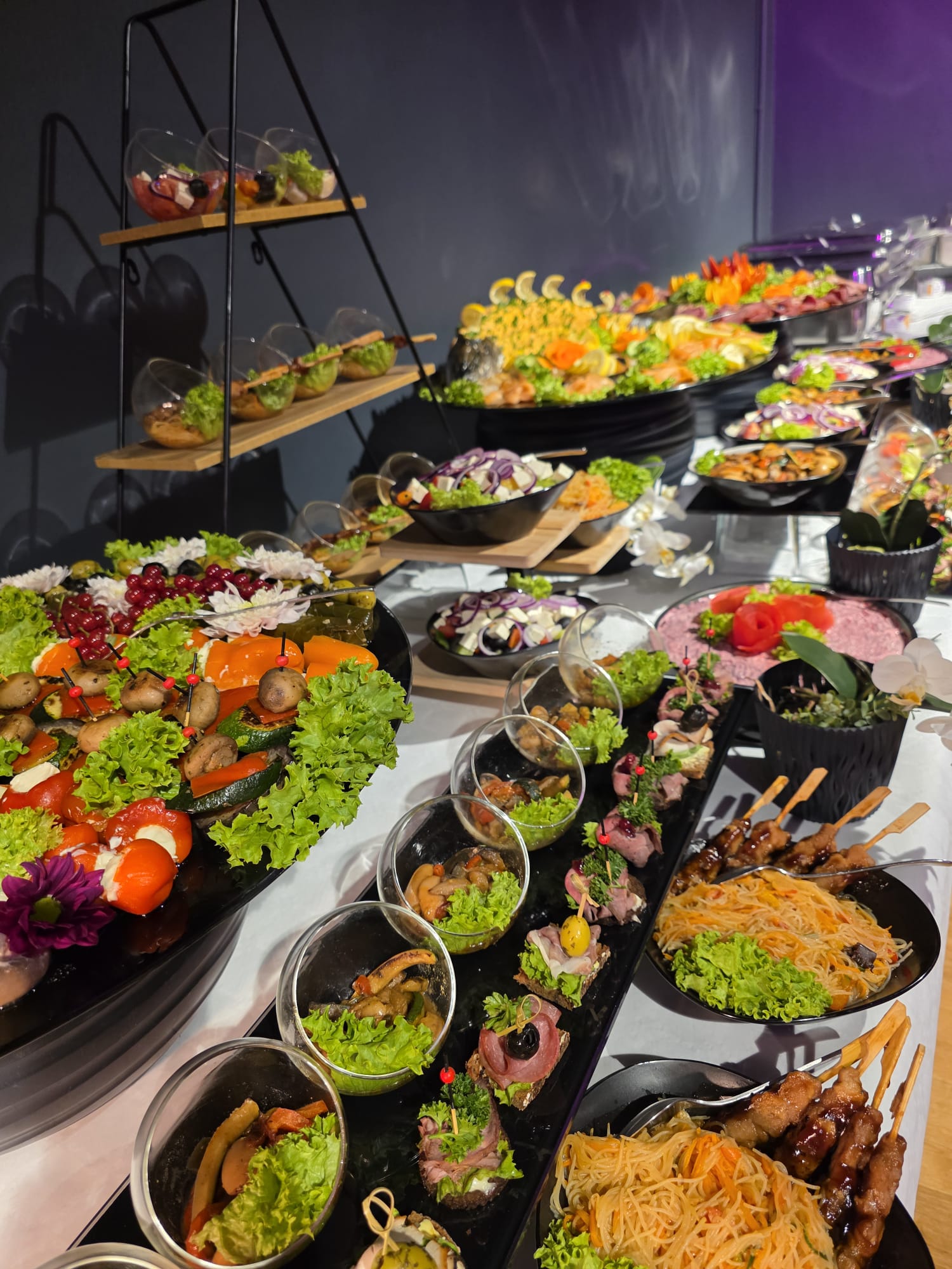 Reich bestücktes Buffet mit Fingerfood-Gläsern, Salaten, Spießen und Etagere